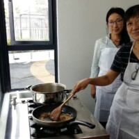 Two women preparing a meal together during a Silver Wellbeing cooking activity.