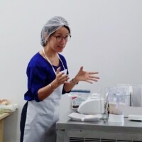 Siew Eng demonstrating food preparation during a Silver Wellbeing cooking workshop.