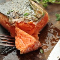 Cooked salmon served with tomatoes and herbs